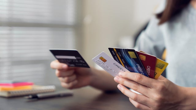 Woman holding credit card and selecting to pay online. The concept of online shopping and payment. 