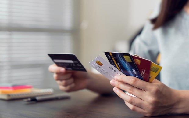 Woman holding credit card and selecting to pay online. The concept of online shopping and payment.