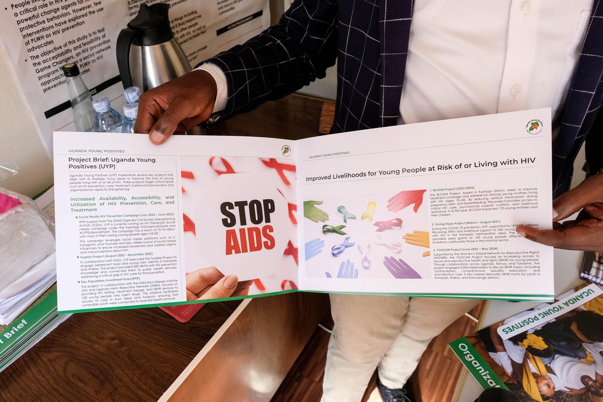Kruish Mubiru, executive director of Uganda Young Positives, displays a pamphlet on HIV prevention in his office, Feb. 12, 2025, in Kampala, Uganda. 