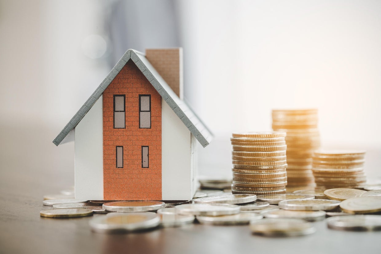 House model and money coins stacks on blur table background. Savings plans for home, loan, investment, mortgage, finance and banking about house concept. 