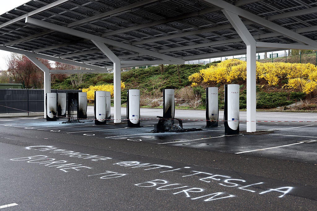 A photo shows damaged and destroyed Tesla charging stations, burnt on the day of a so-called