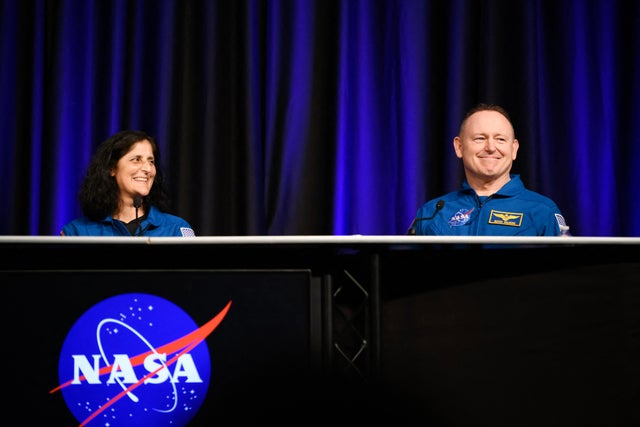 NASA astronauts Suni Williams, left, and Butch Wilmore laugh while answering questions during NASA's SpaceX Crew 9 postflight news conference at the Johnson Space Center in Houston, Texas, March 31, 2025. 
