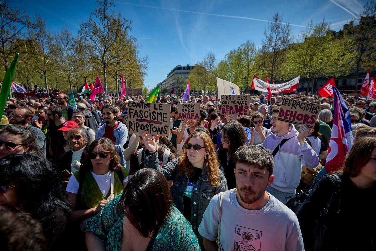 Protesters hold placards and flags as they attend a rally against the far-right, organised by French leftist party La France Insoumise (LFI) and Les Ecologistes (Ecologists party) at the Place de la Republique in Paris