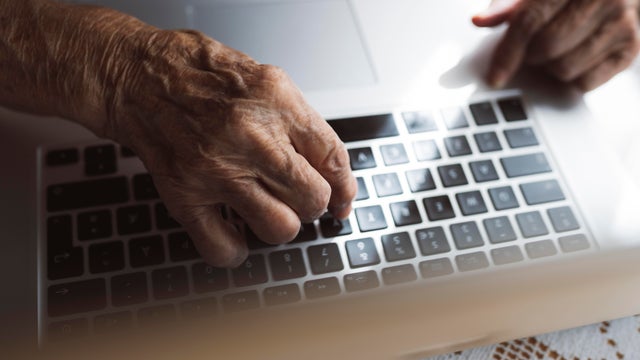 Senior woman learning laptop at home