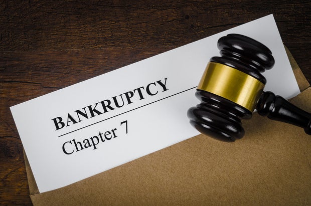 The Bankcrupty Chapter 7 text on Document form and Wooden Gavel on office desk. 