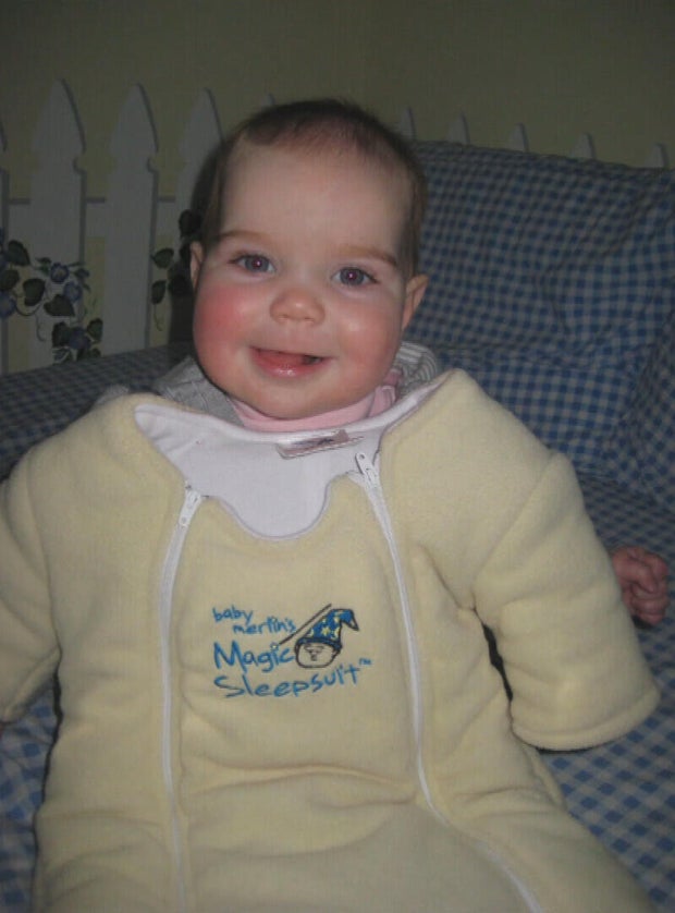 Baby Will Howard has the yellow Magic Sleepsuit over him, he's sitting on a couch 
