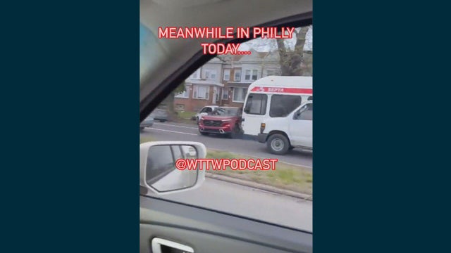 A screengrab from a video taken from inside a car, outside a bus is seen pushing a red SUV on Roosevelt Boulevard 