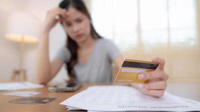 Stressed Asian woman seeing too high monthly expenses. 