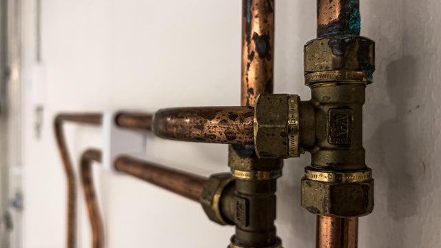 Rusty copper pipes for drinking water installation background 
