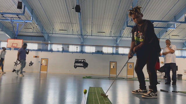 A child putts on a putting green 