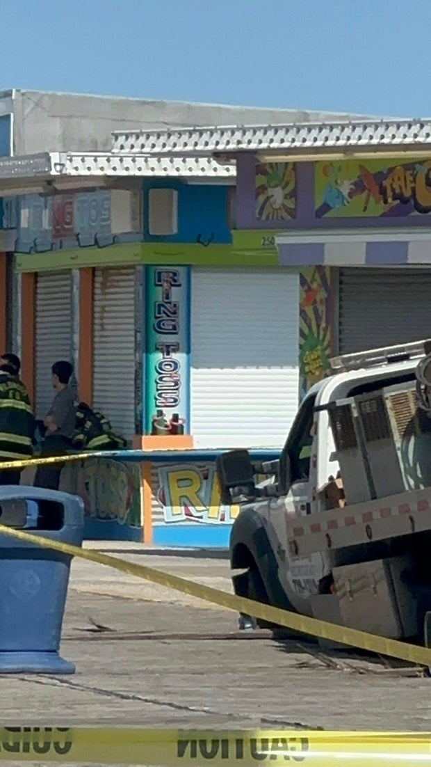 Close-up photo of the truck surrounded by yellow caution tape, the truck's front wheels broke through the boards of the Wildwood boardwalk 