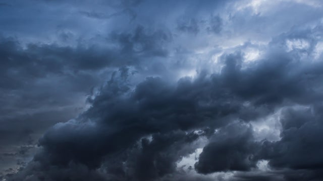Black ominous storm clouds create textured background element 