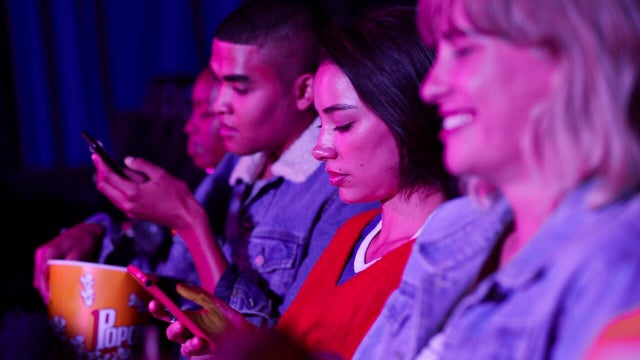 People using phones at theater 
