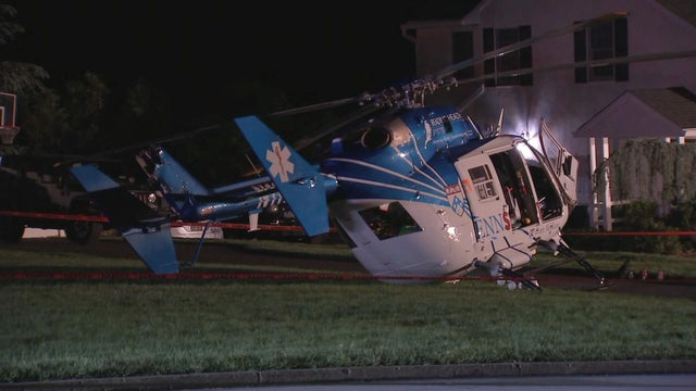 A small helicopter is seen on the driveway of a home 