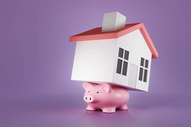 HELOC vs. reverse mortgage: What experts say seniors should consider now 1 Flattened pink piggy bank carry a toy house on its back on a purple background. Illustration of the concept of the burden of mortgage loans and heavy debt