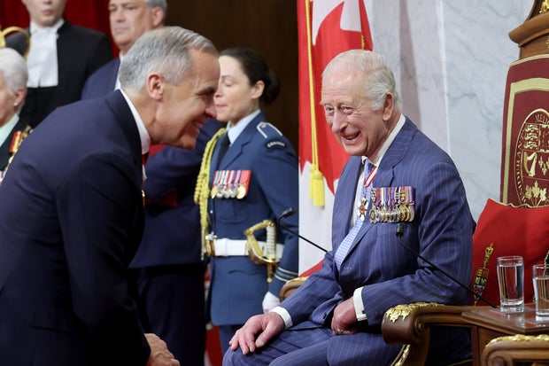 King Charles III smiles at Prime Minister of Canada Mark Carney before opening the 45th Parliament of Canada by delivering the Speech from the Throne during an official visit to Canada on May 27, 2025 in Ottawa, Ontario.