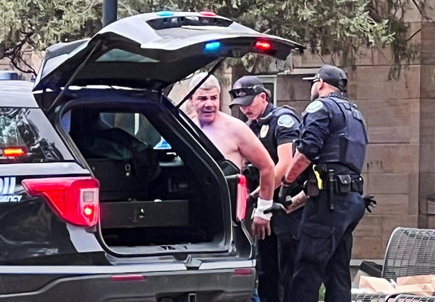 Law enforcement officers detain a suspect  after an attack that injured multiple people, in Boulder 
