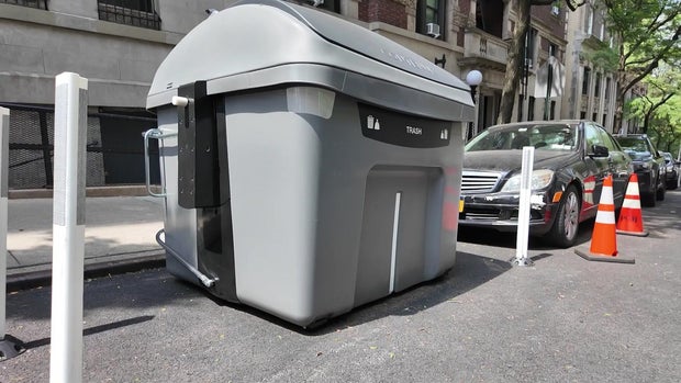 A large Empire trash bin along a curb in New York City. 