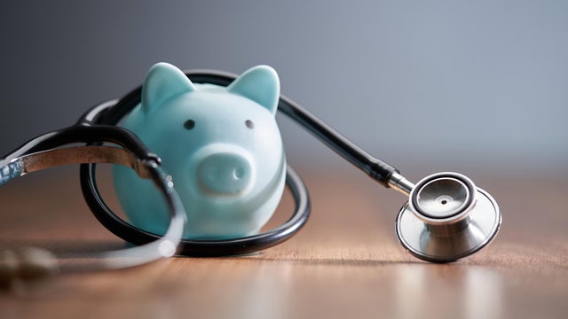 Close-up of piggy bank with stethoscope on table 