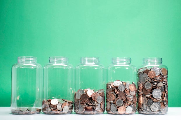 Savings Growth Concept - 5 Cans of Coins Rises 