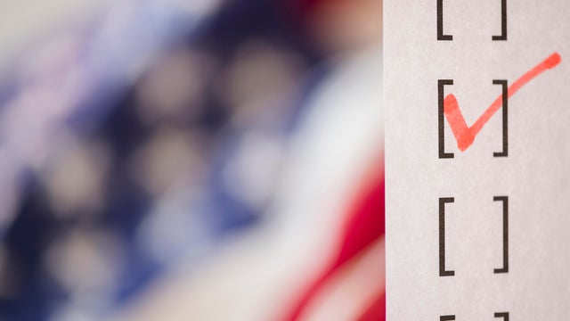 Close up of voting ballot near American flag 