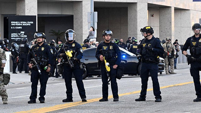 U.S. Border Patrol and Custom officers and U.S. Immigration and Customs Enforcement agents stand guard outside the federal building in Los Angeles on Wednesday, June 11, 2025. 