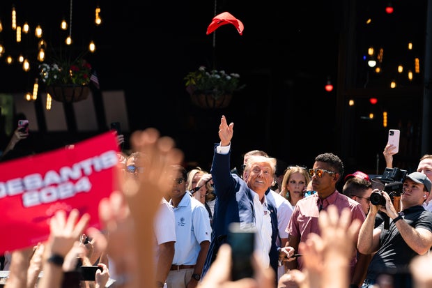 Former President Donald Trump tossed a hat in the air while supporters cheer for him during the 2023 Iowa State Fair on Saturday, Aug. 12, 2023. 