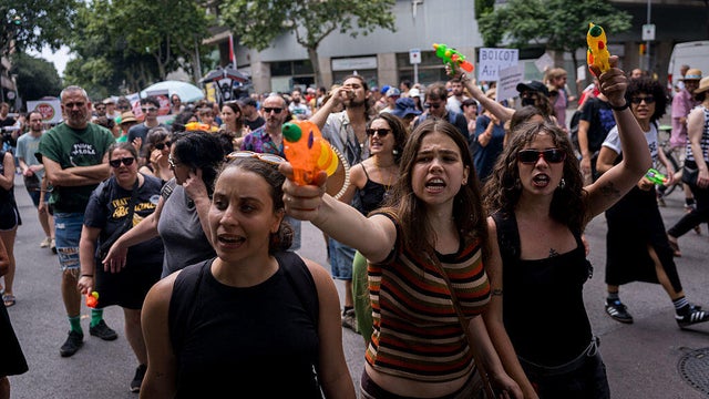 People are seen spraying tourists and buildings with water 