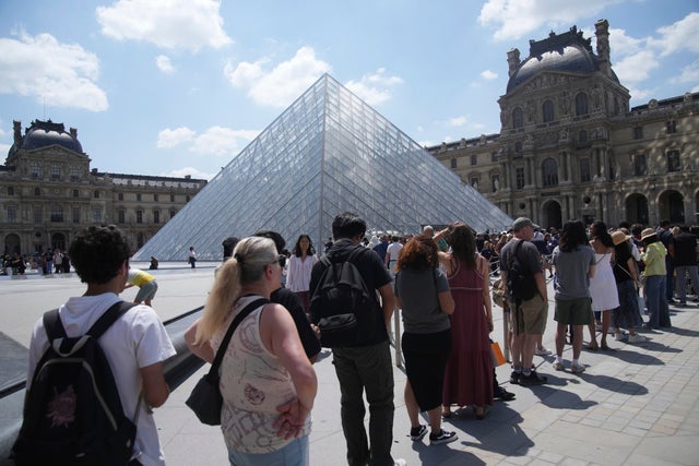 Tourists wait in line outside the Louvre museum, which failed to open on time June 16, 2025, in Paris. 
