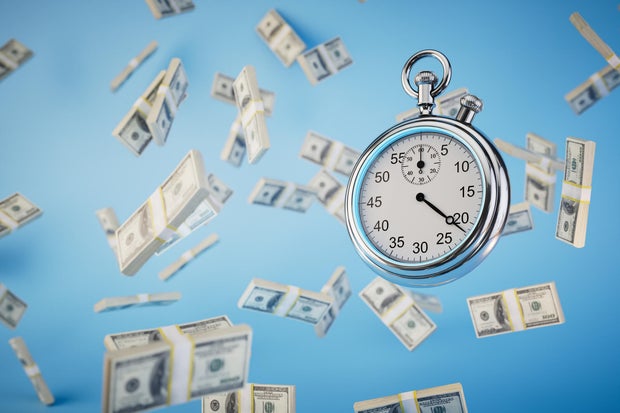 Is a high-yield savings account worth it in today's economy? Here's what savings experts think. limited time to earn money. a stopwatch and packs of dollar bills flying across a blue background. 3D render