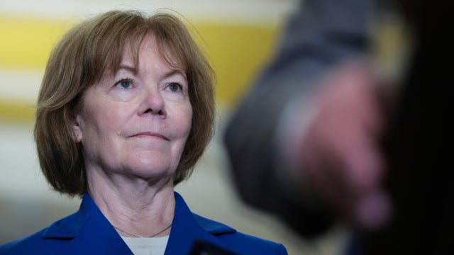 Sen. Tina Smith listens as Leader Chuck Schumer speaks to reporters following the weekly Democratic policy luncheon at the U.S. Capitol Building on June 10, 2025 in Washington, DC. 