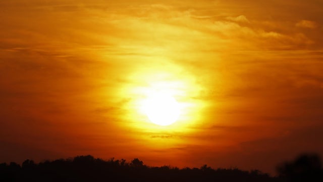 Orange sky with bright sun symbolizing climate change and global warming 