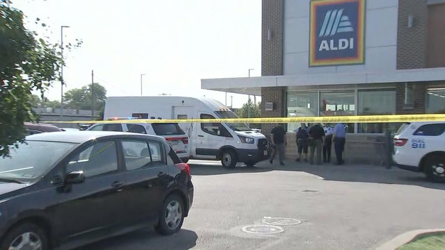 Police officers and police tape are seen near an Aldi grocery store after a robbery 