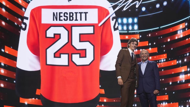 Jack Nesbitt, left, stands with NHL commissioner Gary Bettman after being drafted by the Philadelphia Flyers, a picture of a Nesbitt Flyers jersey is in the background 
