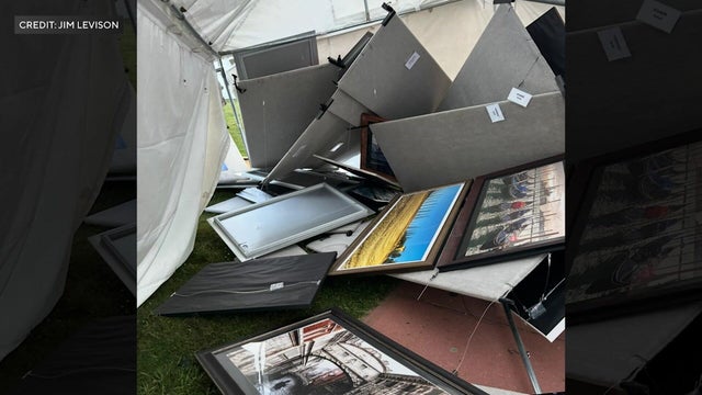 A tent with multiple framed photographs is damaged 