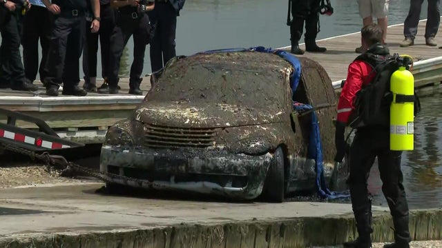 A barnacle-covered PT Cruiser is pulled out of Mount Sinai Harbor 