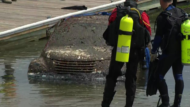 A barnacle-covered PT Cruiser is pulled out of Mount Sinai Harbor 