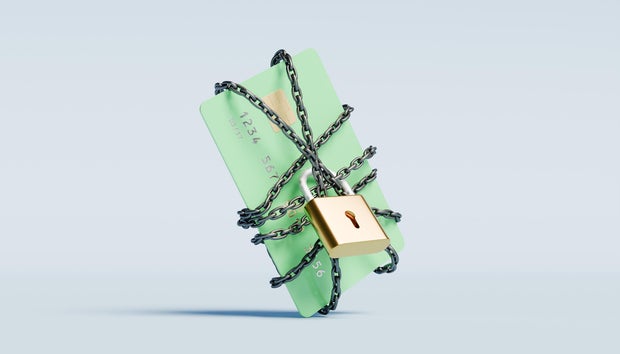 Green credit card wrapped in a chain with a lock 