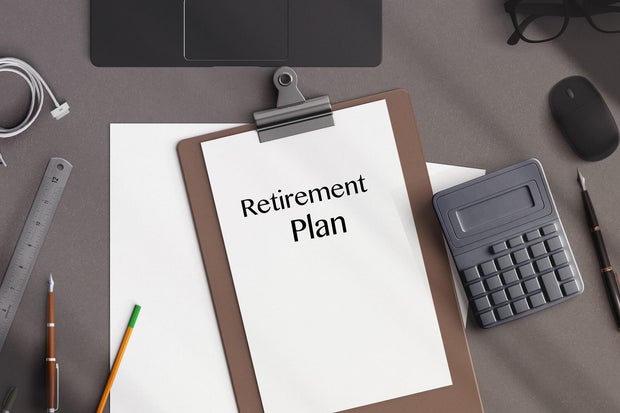 directy above workspace with laptop and office supplies.Retirement plan reminder