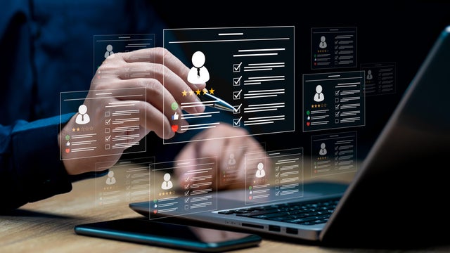 HR management with AI recruiting technology concept: Businessman uses a laptop recruitment process to check the scores and qualifications of applicants through an online system, Best human resource 
