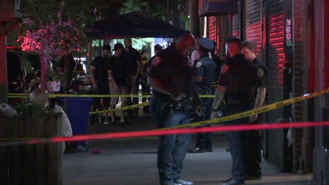 Crime scene tape and police officers on an East Harlem sidewalk 