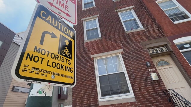 A sign says Caution, Motorists not looking and has tally marks for crashes in the area 