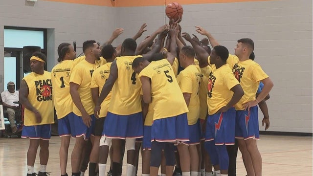 A group of men huddle together and put their hands in before a basketball game 