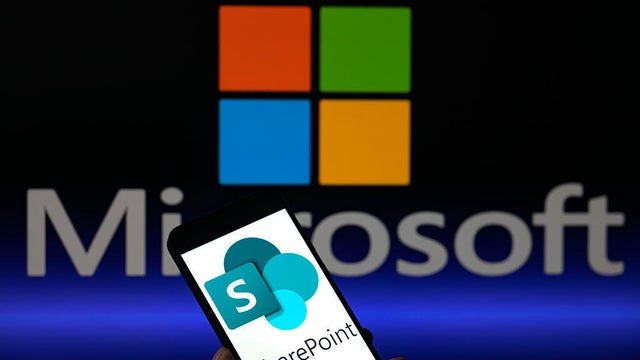 The SharePoint logo is displayed on a mobile phone with Microsoft visible on the screen, in this photo illustration in Brussels, Belgium, on July 23, 2025. 