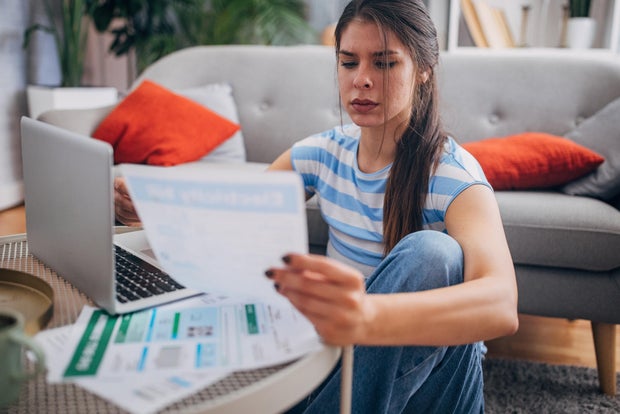 Woman reviewing documents with laptop on the table. 