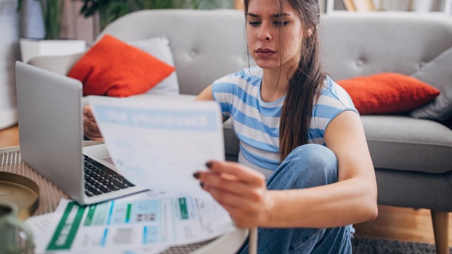 Woman reviewing documents with laptop on the table. 