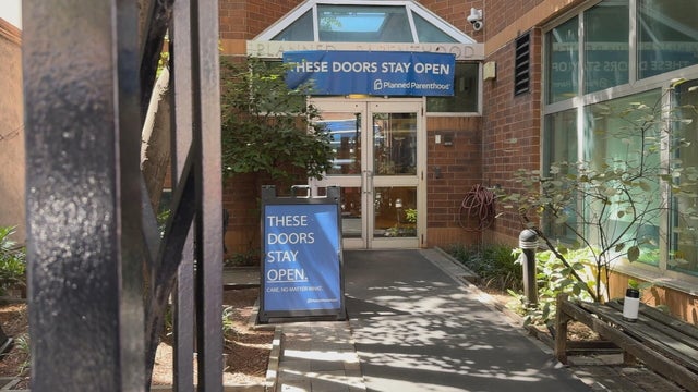 A Planned Parenthood clinic, a banner hanging over the sign says These doors stay open with the Planned Parenthood logo 
