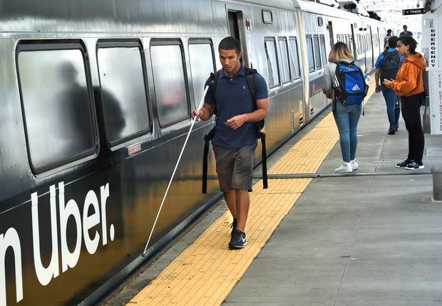 A blind man catches a train in Denver, Colorado 