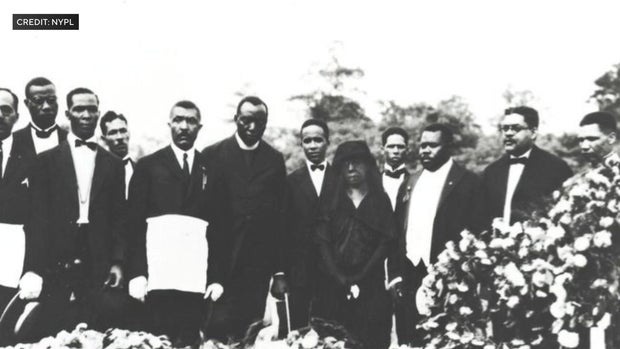 Mourners attend the burial of John Edward Bruce 