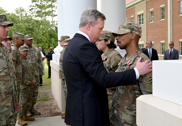 Army Secretary Dan Driscoll comforts Sgt. Aaron Turner after Turner received the Meritorious Service Medal with five other soldiers outside Fort Stewart in Georgia, Aug. 6, 2025. 